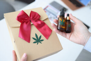 Female hands holding gift wrap with marijuana closeup. Legal sale of marijuana concept