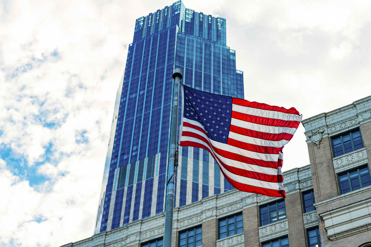 Veterans Day in America. City with flag. American Flag Waving in sky. 4th of July with American flag. Independence Day. National patriotic symbol. USA American flag. Memorial Day.