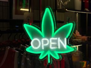 Neon cannabis leaf open sign glowing outside shop on Khao San Road. High quality photo